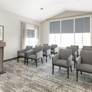 A small conference room with a podium and rows of chairs facing forward.
