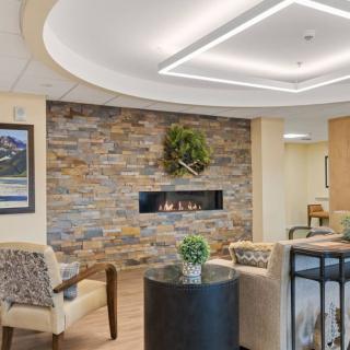 A modern lobby with a stone wall fireplace and comfortable seating.