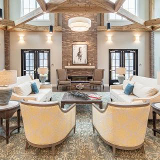 A beautifully designed living room featuring elegant furniture, a brick wall, and a modern chandelier.