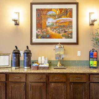 A welcoming lobby area featuring a beverage station and decorative artwork.