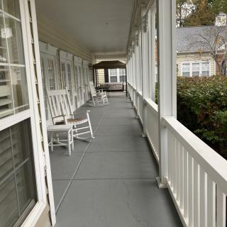 A cozy porch with rocking chairs lining the walkway, perfect for relaxation.