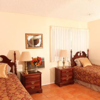A cozy bedroom with twin beds and traditional wooden furniture.
