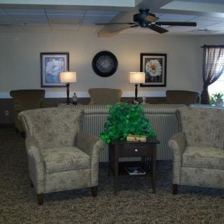 A cozy living room setup with armchairs, a side table, and decorative elements.