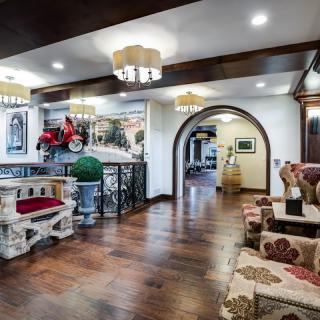 A cozy lobby area featuring traditional decor with wood flooring and elegant chandeliers.