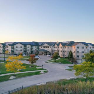 A large residential apartment complex with well-maintained landscaping at sunset.