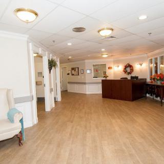 A bright and spacious lobby area with a reception desk, comfortable seating, and elegant lighting.