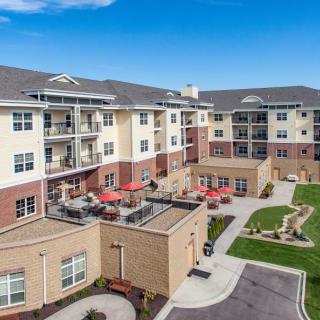 A modern apartment complex with a landscaped courtyard and outdoor seating.