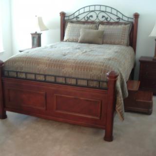 A well-furnished bedroom with a wooden bed and matching side tables.