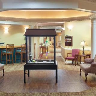 A cozy lobby area featuring comfortable seating and a central display case.