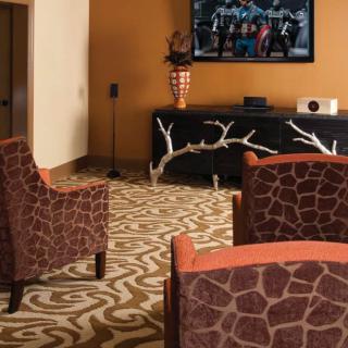 A stylish living room with animal print chairs and a home theater setup.