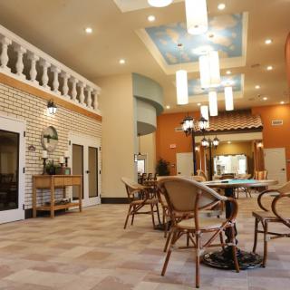 A spacious and elegantly decorated restaurant interior with ample seating and modern lighting fixtures.