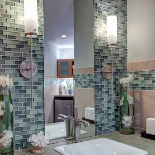 A modern bathroom featuring stylish tile work, elegant lighting fixtures, and tasteful decor.