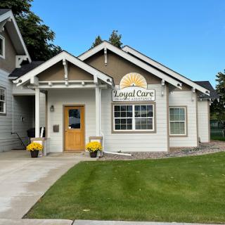 A charming single-story house with a welcoming entrance and well-maintained landscaping.