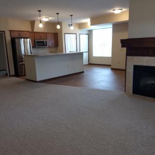 An open floor plan featuring a kitchen with an island and a living room area complete with a fireplace.