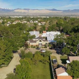 An aerial view of a residential area with buildings surrounded by lush green trees and mountains in the background.