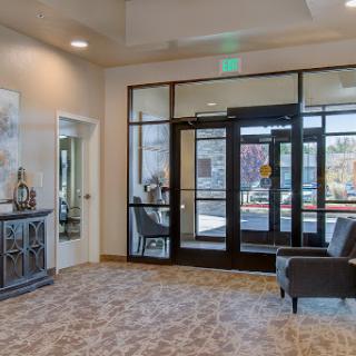 A modern lobby featuring a cozy seating area and large glass doors that provide ample natural light.