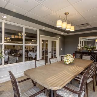 A well-decorated dining room featuring a large table, chairs, and elegant lighting.