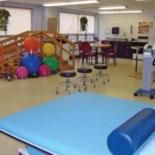 A well-equipped physical therapy room with fitness balls and exercise equipment.