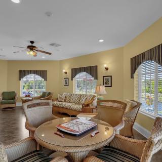 A cozy living room featuring a seating area with comfortable chairs and large windows.
