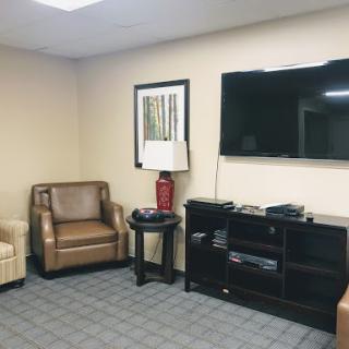 A cozy waiting room featuring comfortable seating and a television.