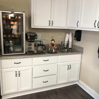 A well-organized kitchen coffee station with cabinets, a beverage refrigerator, and a coffee maker.