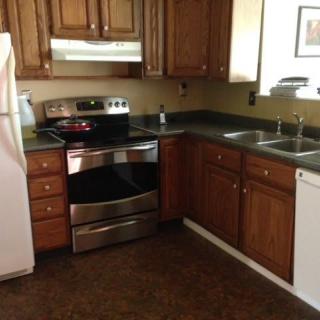 A modern kitchen with wooden cabinets and standard appliances.