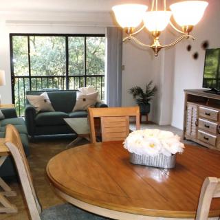 A cozy living room and dining area with wooden furniture and elegant lighting.