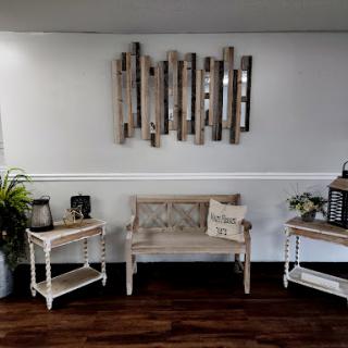 A cozy living room setup featuring a wooden bench, decorative tables, and wall art.