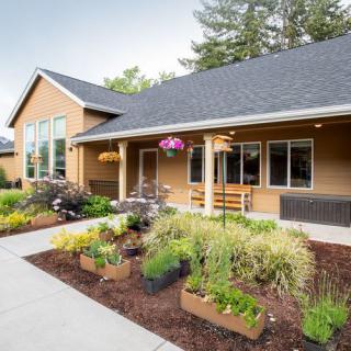 A charming house with a beautifully landscaped garden and flower beds in front.