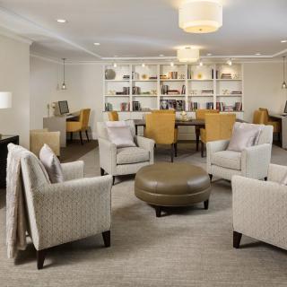 A modern living room with comfortable seating and a bookshelf.