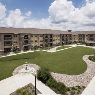 A view of a well-maintained apartment complex with landscaped gardens and walkways.
