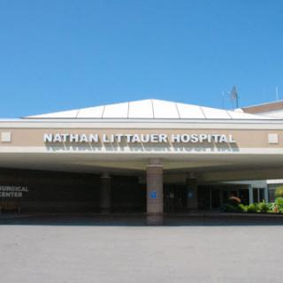 Entrance of Nathan Littauer Hospital under clear blue skies.