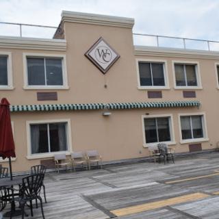 View of a restaurant building with outdoor seating and decorative awning.
