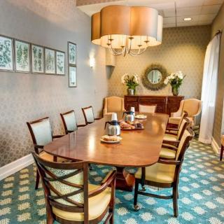 A stylish dining room featuring a wooden table, chairs, and elegant lighting.
