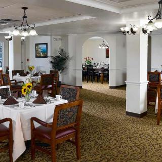 A beautifully decorated dining room with elegant table settings and classic lighting fixtures.