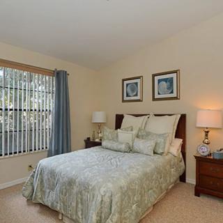 A cozy bedroom with a bed, side tables, and soft lighting.