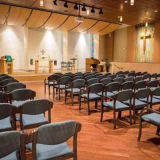An interior view of a church with rows of seating facing the altar.