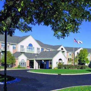 A residential building with well-maintained landscaping and flags near the entrance.