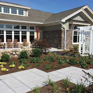 A well-landscaped garden with a pathway leading to a modern house.