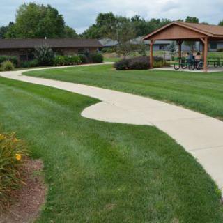 A scenic view of a landscaped park with a winding pathway and gazebo.