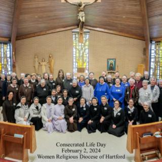 A group photo from Consecrated Life Day, featuring women religious from the Diocese of Hartford, inside a church with stained glass windows.