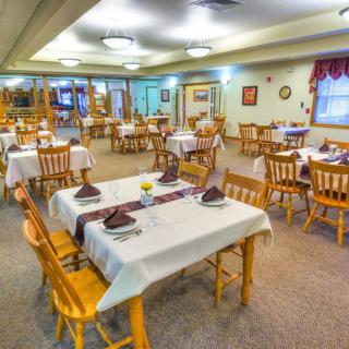 A cozy dining room with neatly arranged tables and chairs, ready for guests.