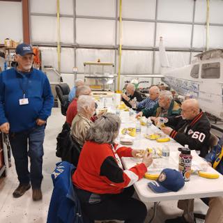 A group of individuals enjoying a meal together in a warehouse setting.