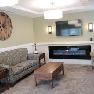 A cozy living room featuring a comfortable sofa, coffee table, modern fireplace, and a wall-mounted television.