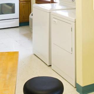 A laundry area within a kitchen, featuring a washing machine and dryer next to an oven.