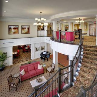 A hotel lobby with a grand staircase and comfortable seating area.