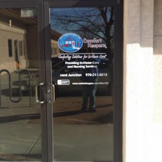 Entrance door with company signage reflecting the surroundings.