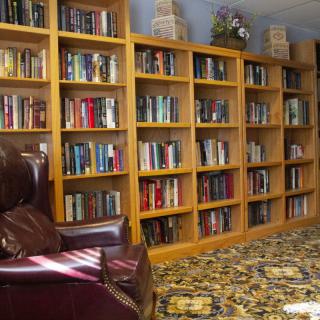 A cozy library corner with bookshelves filled with books and a comfortable armchair.