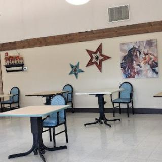 Empty dining area with tables, chairs, and patriotic wall decorations.
