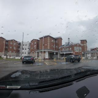 A view of a hotel from inside a car on a rainy day.